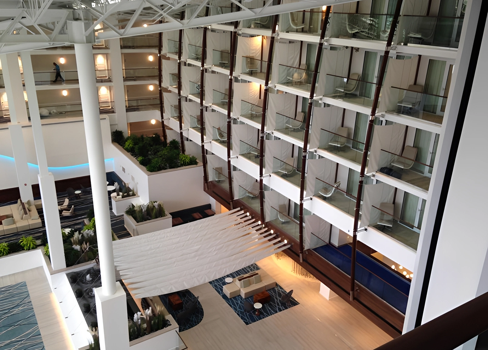 Modern hotel interior with balconies and seating.